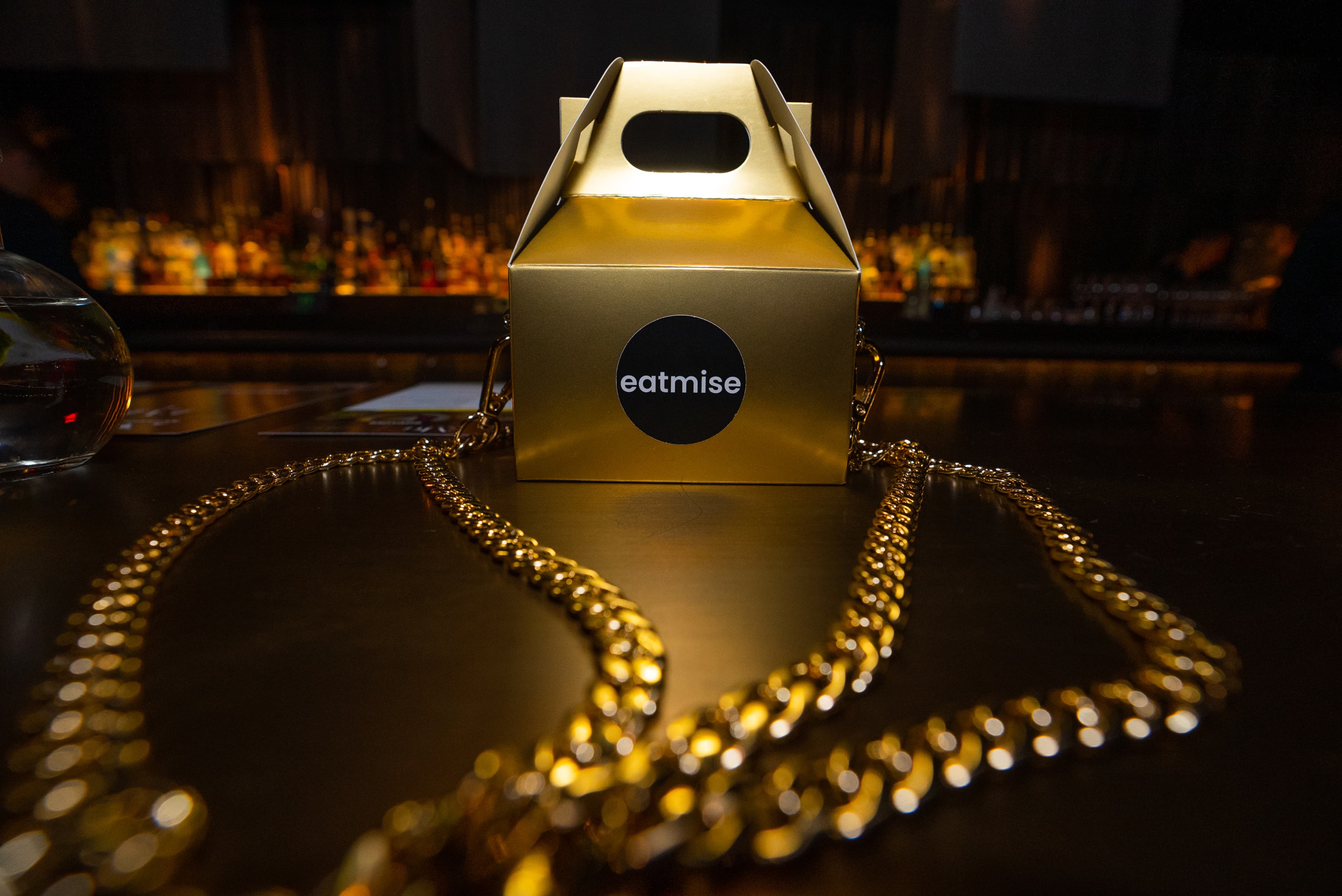 EatMise box with gold chain on a dark surface
